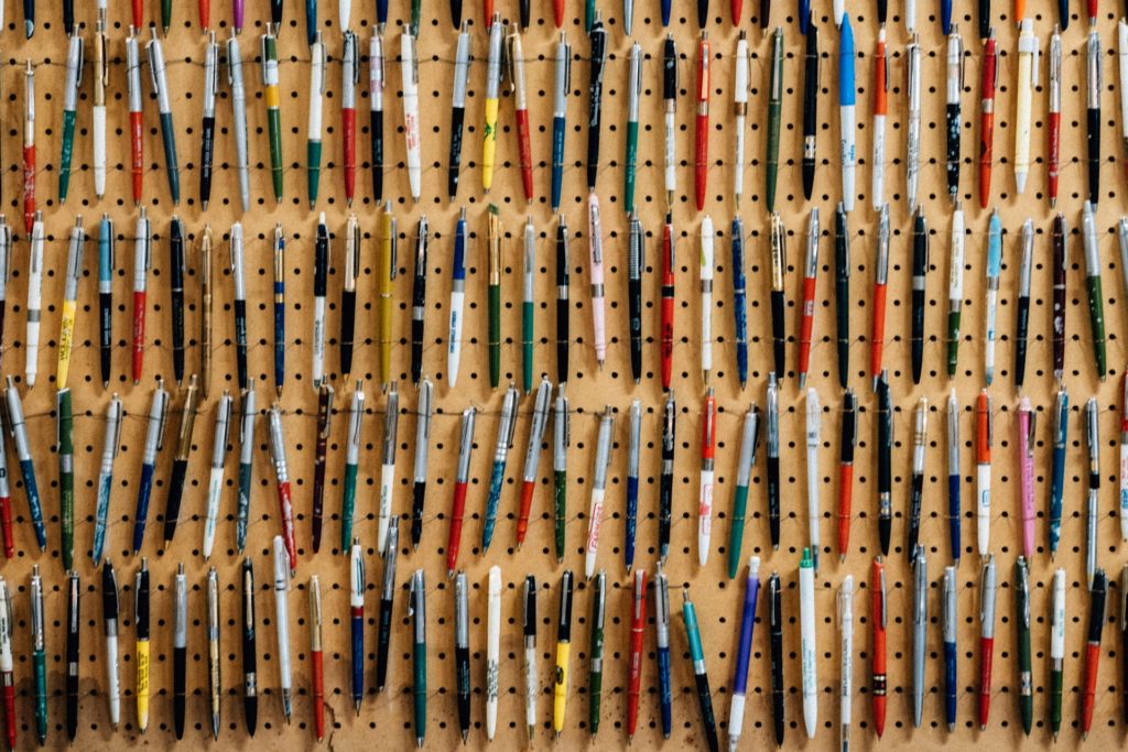 A wall covered in different types of pens