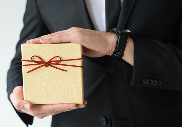 A man in suite with holding a corporate promotional gift
