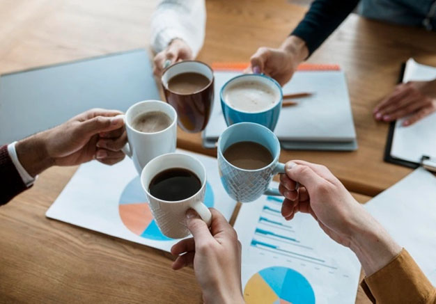 Hands toasting with promotional mugs at a corporate meeting