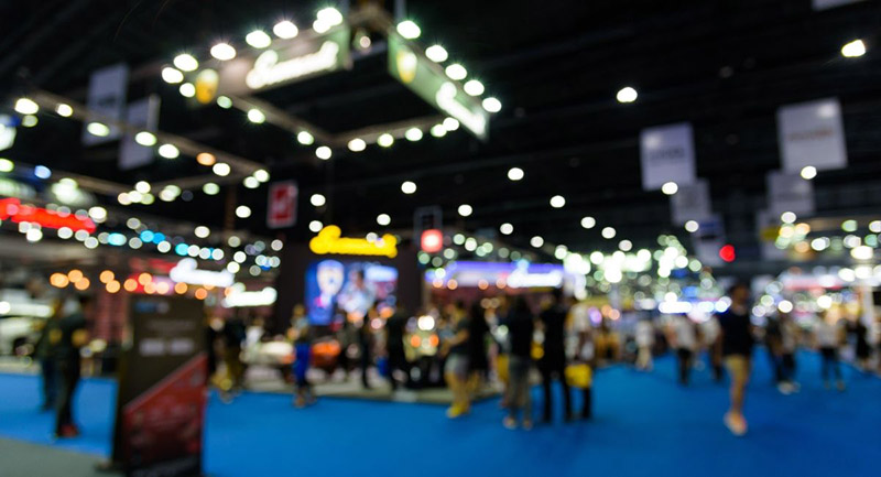 Blurred image of a succesful tradeshow where people is receiving tradeshow swag